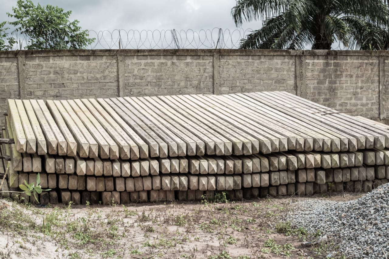 Poteaux en béton alignés contre le mur d’enceinte